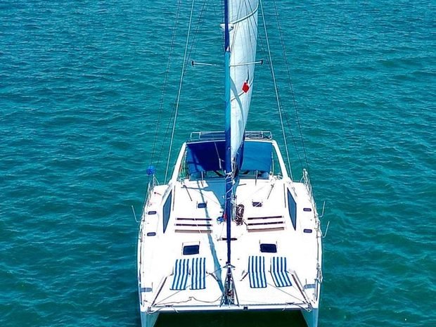 A catamaran under sail seen head on from above