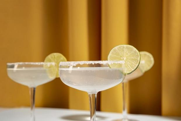 Two margarita coupes with lime